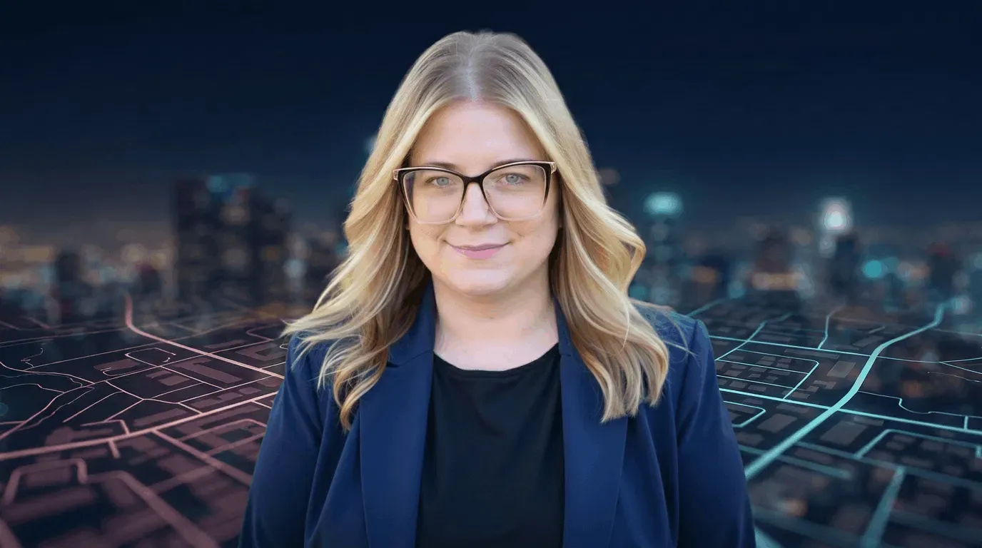 Randi Bagley smiling in front of a glowing city map at night